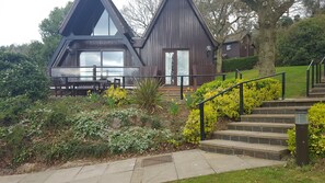 A modern house with a symmetrical design, featuring a central door and two large windows.