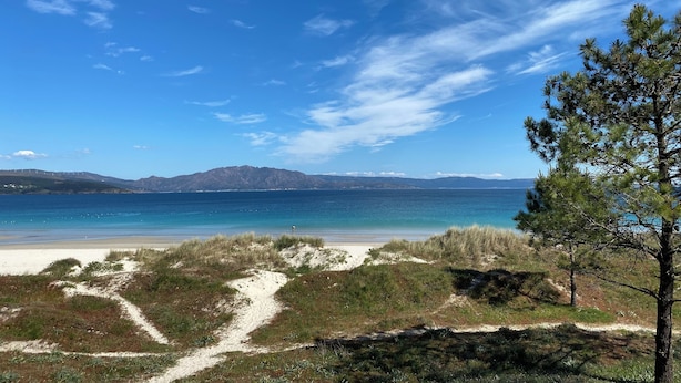 A beach with a clear sky, a path leading to the water, and distant mountains. - Apto Las Dunas de Langosteira en Finisterre (finisterre)