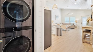 Een moderne keuken met inbouwapparatuur, een eethoek met tafel en stoelen, en een woonkamer met een bank en salontafel.
