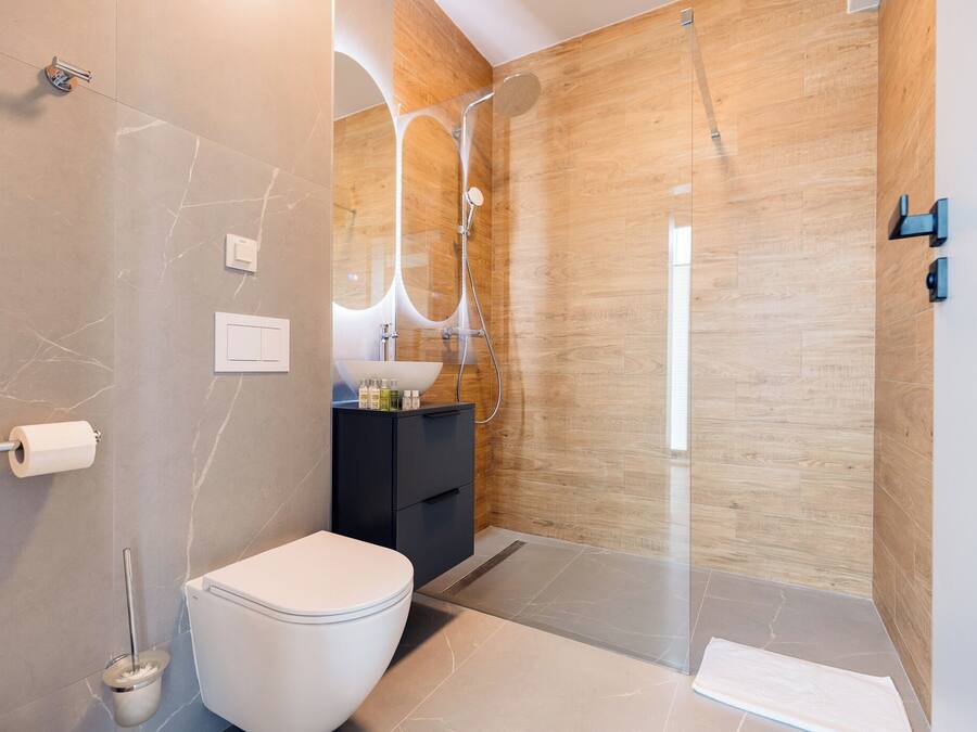 A modern bathroom with a toilet, a sink, and a shower area.