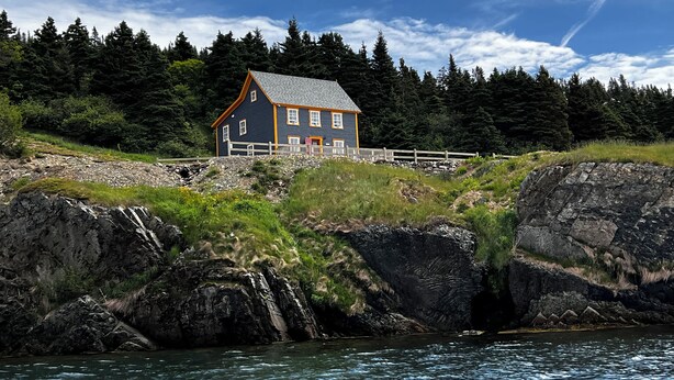 A house by a rocky shoreline with a forest in the background. - Bellecroft House - Beautifully renovated, stunning water-front getaway property (Trinity East)