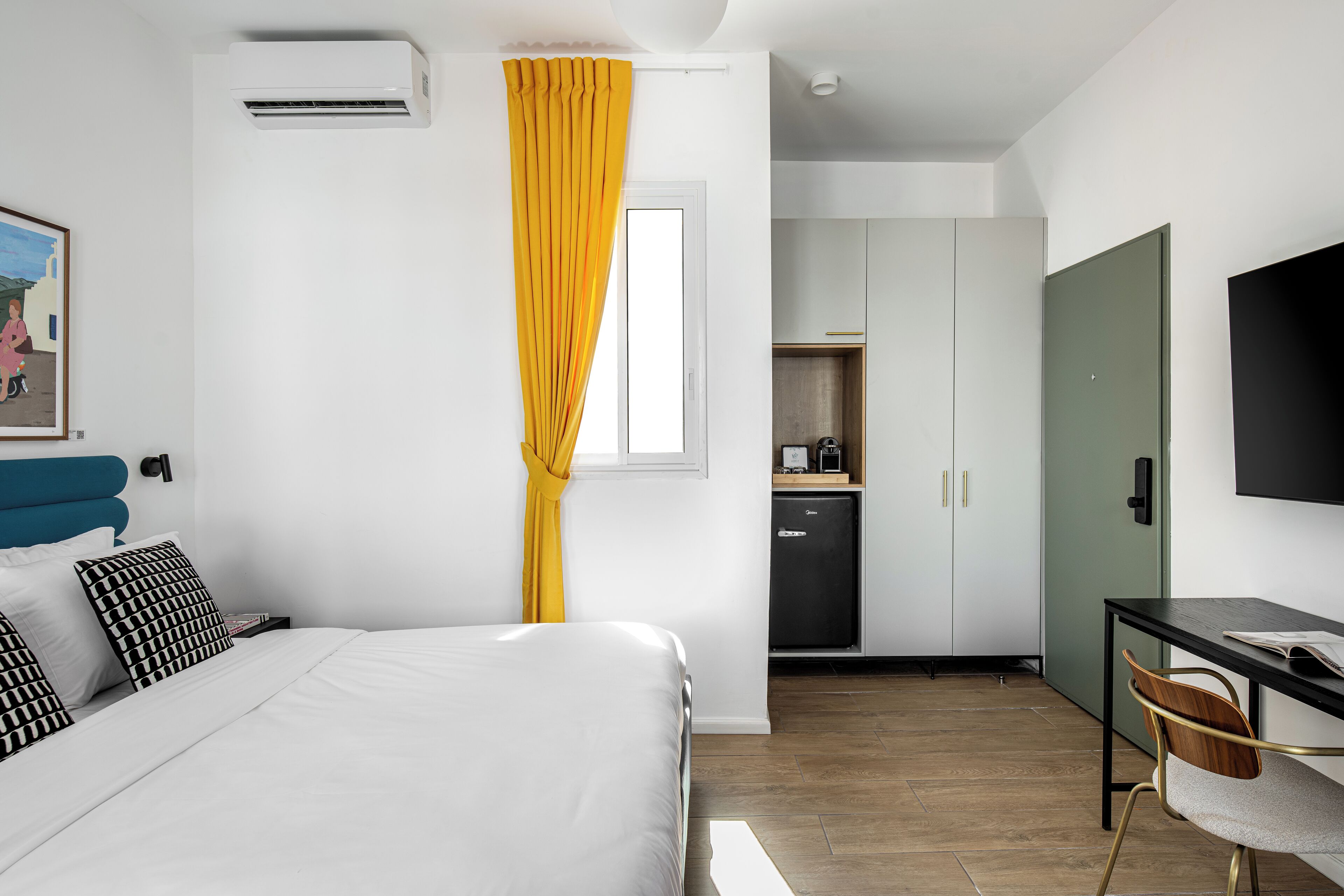 Une chambre d’hôtel comprenant un lit, un bureau, une chaise, une télévision et une armoire.
