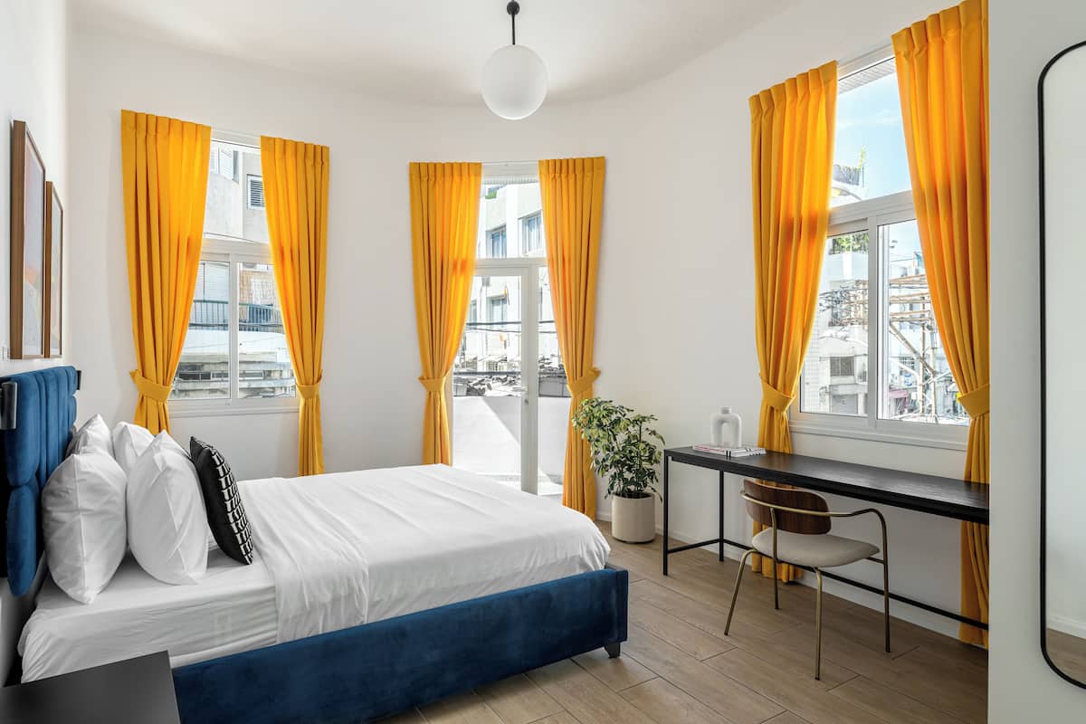 A modern bedroom with a bed, a desk, and a chair.