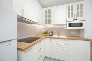 Fridge, microwave, stovetop, cookware/dishes/utensils - Emilii Plater 55 Warsaw | Cozy Apartment | City center of Warsaw (Warszawa)