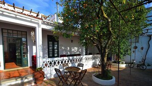 A courtyard with a table and chairs, a potted plant, and a bicycle. - Casa de Serpa - turismo rural (Serpa)