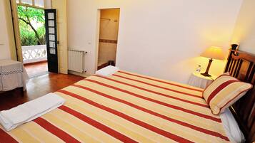 Une chambre d’hôtel avec un lit, une petite table avec une lampe et une vue sur l’extérieur.