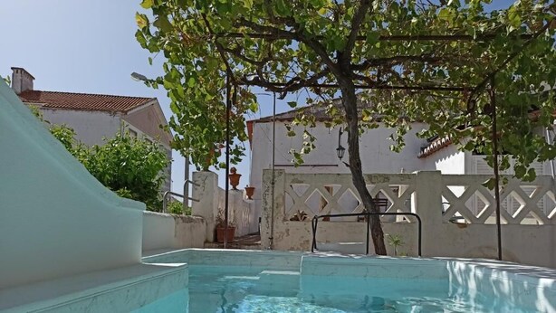 A swimming pool with a white deck, surrounded by a white fence and a tree. - Casa de Serpa - turismo rural (Serpa)