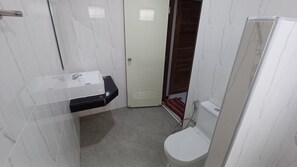 A small bathroom with a white sink, toilet, and shower. - Tropical Island Retreat in Baan Tai, Thailand (Ko Pha-ngan)