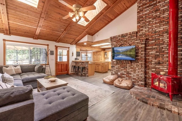 A cozy living room with a fireplace, a kitchen area, and a dining space.