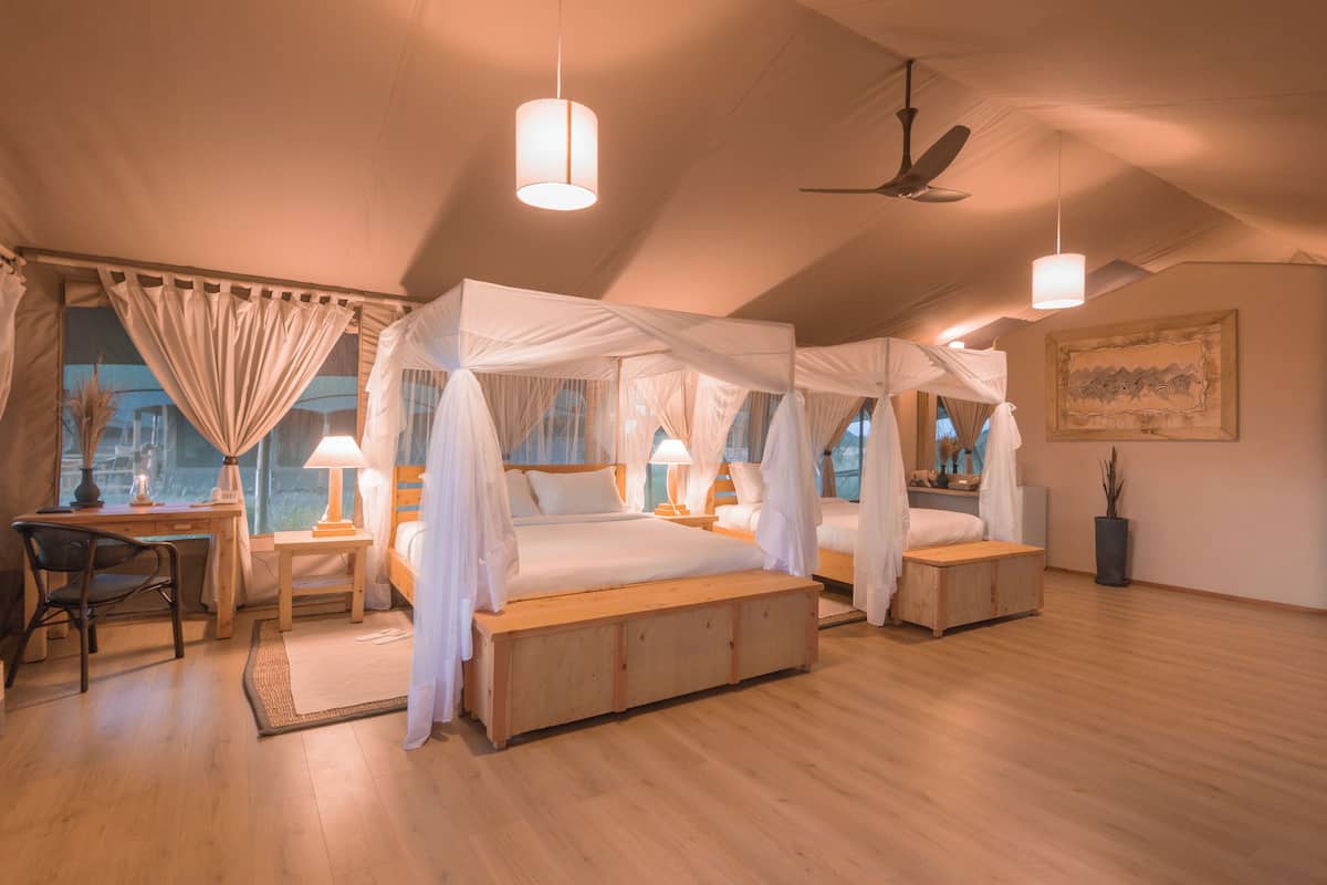 A bedroom with a canopy bed, a desk, and a chair.