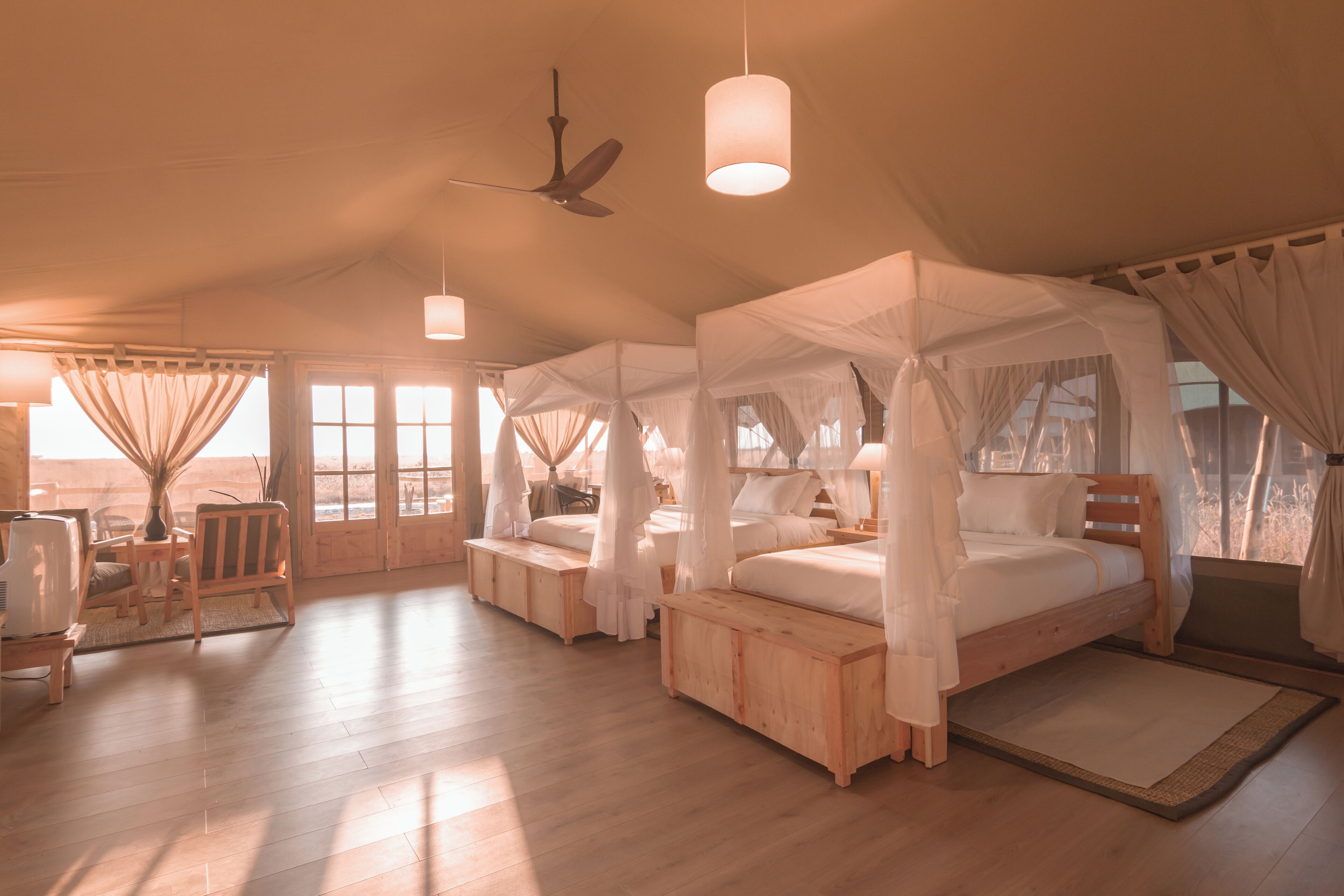 A spacious room with a large bed, a ceiling fan, and a television.