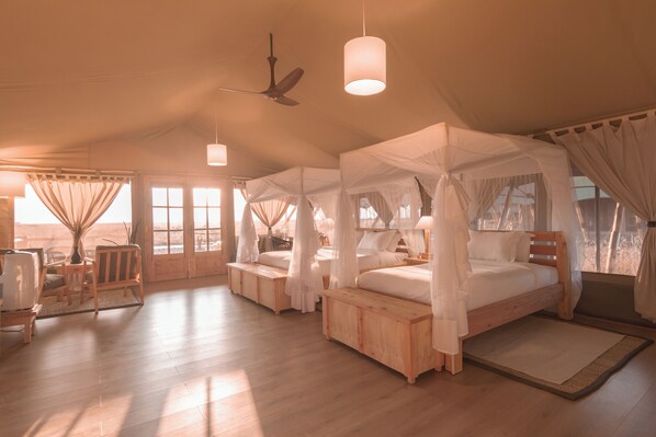 A spacious room with a large bed, a ceiling fan, and a television. - Maisha Sweetwaters Camp (Nanyuki)