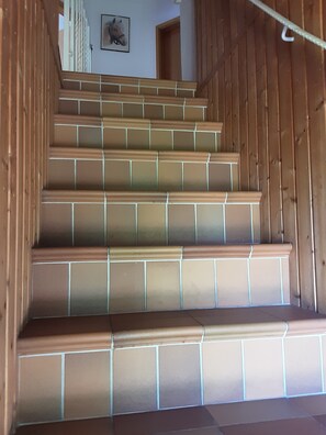 A staircase with brown tiles and wooden railings.