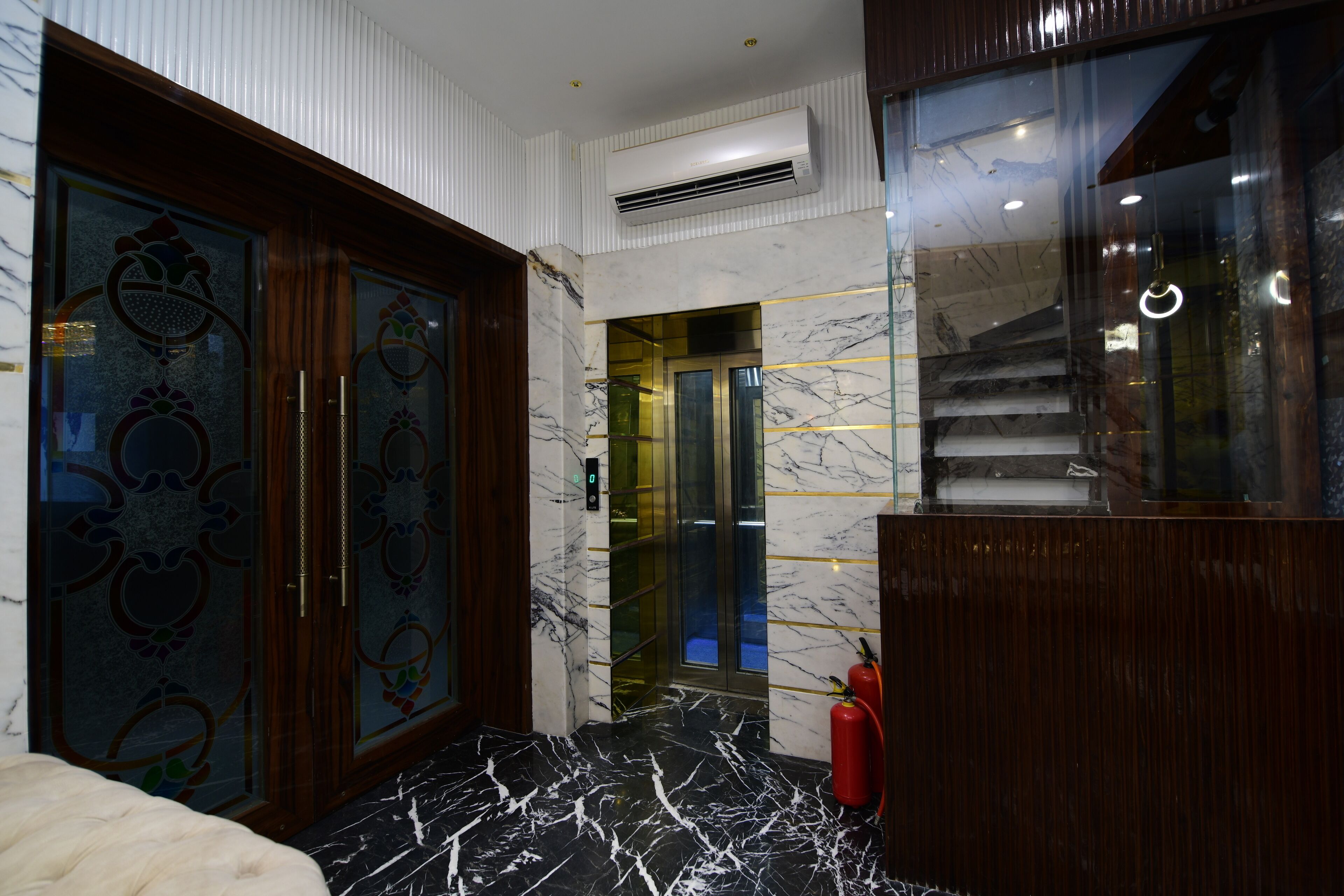 A modern bathroom with a marble floor, a glass shower enclosure, and a wooden vanity.