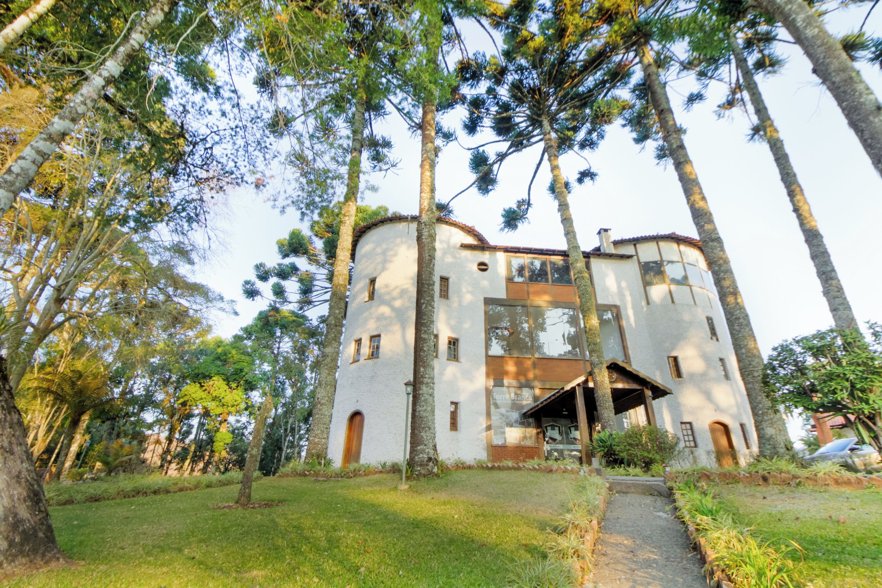 Un edificio de dos pisos con fachada blanca, entrada central y un pequeño porche.