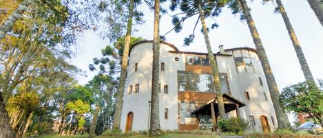 Un edificio de dos pisos con fachada blanca, entrada central y un pequeño porche.