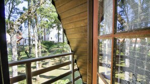 Ein hölzerner Balkon mit Blick auf einen Garten und ein Gebäude im Hintergrund.