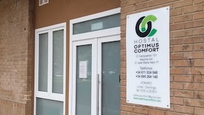 Een gevel met een bordje voor Hostal Optimus Comfort.