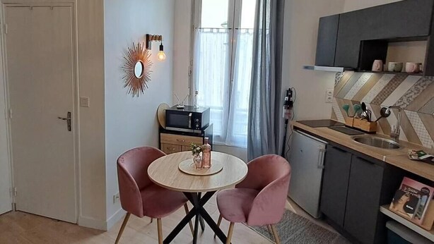 Et kompakt køkken med spiseplads, en mikroovn og et lille køleskab.