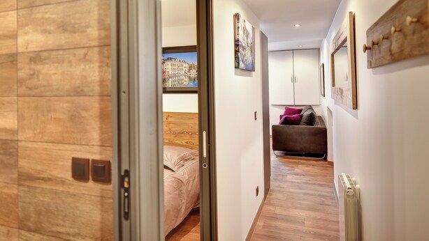 A hallway with a bed, a sofa, and a radiator. - Cozy apartment between lake and mountains (Annecy)