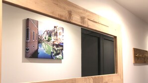 A wall-mounted artwork depicting a canal scene, a black door, and a wooden panel. - Cozy apartment between lake and mountains (Annecy)