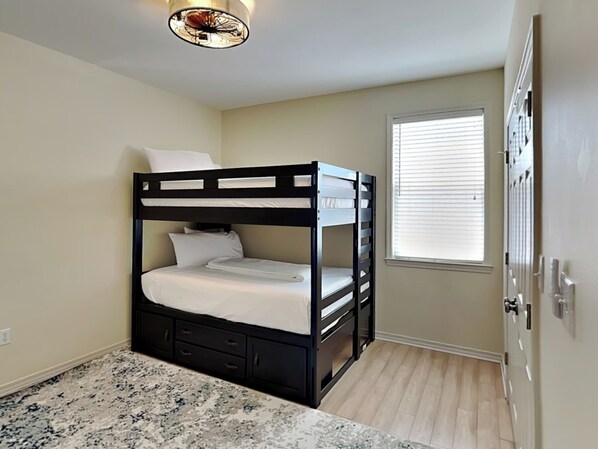 A bunk bed room with a marble floor, a window with blinds, and a door. - Corner Castle | Central Location + Access to Pool & Beach! (Destin)