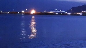 A nighttime view of a calm body of water reflecting city lights.