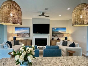 Una sala de estar con chimenea, dos sofás, una mesa de centro y televisor.