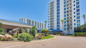 Ein modernes Hotel mit Innenhof, mehreren Balkonen und einem gepflegten Garten.