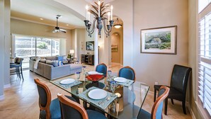 A dining area with a glass table, chairs, and a chandelier. - Marco Island Home w/ Private Pool: 3 Mi Beach! (Marco Island)