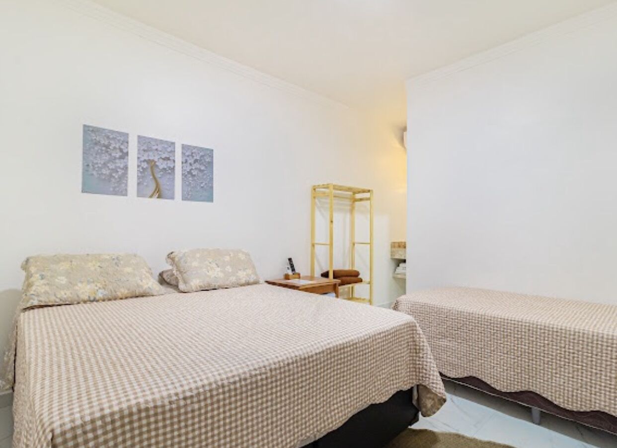 Un dormitorio con dos camas, una mesita de noche y un espejo.
