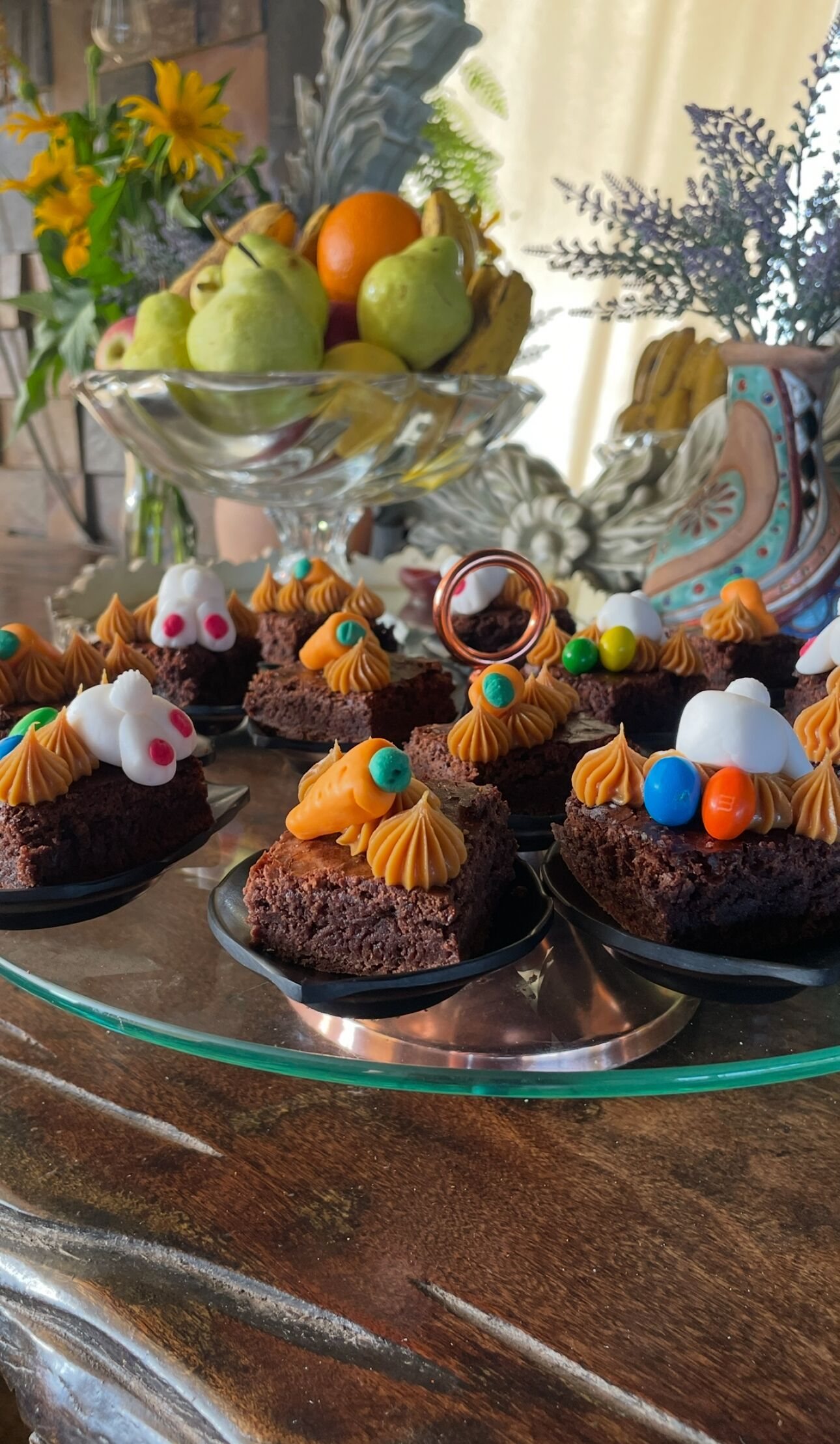 A dessert table with chocolate brownies topped with various decorations.