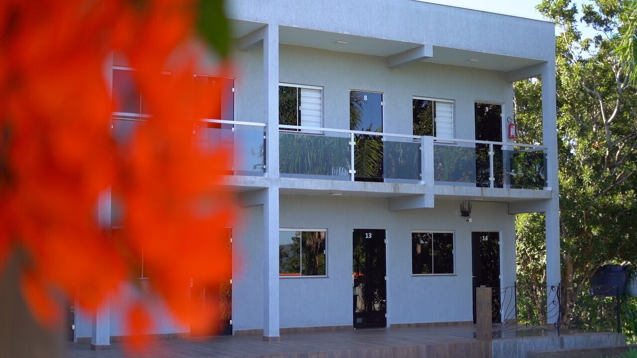 A multi-story building with balconies and numbered doors.
