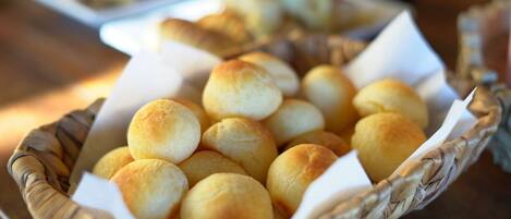 A basket filled with round, golden-brown bread rolls.