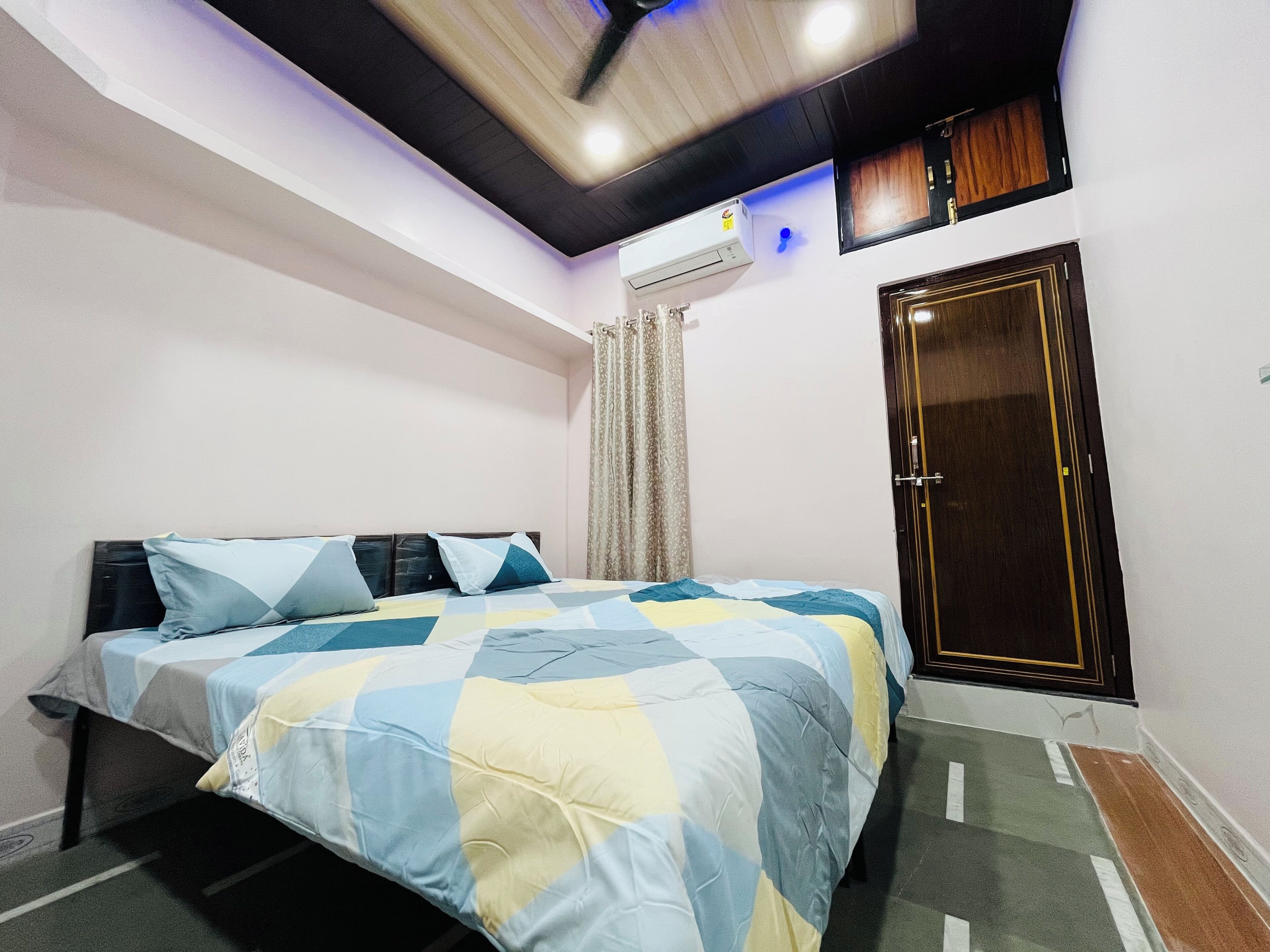 Une chambre avec un lit, une armoire, un climatiseur et un ventilateur de plafond.