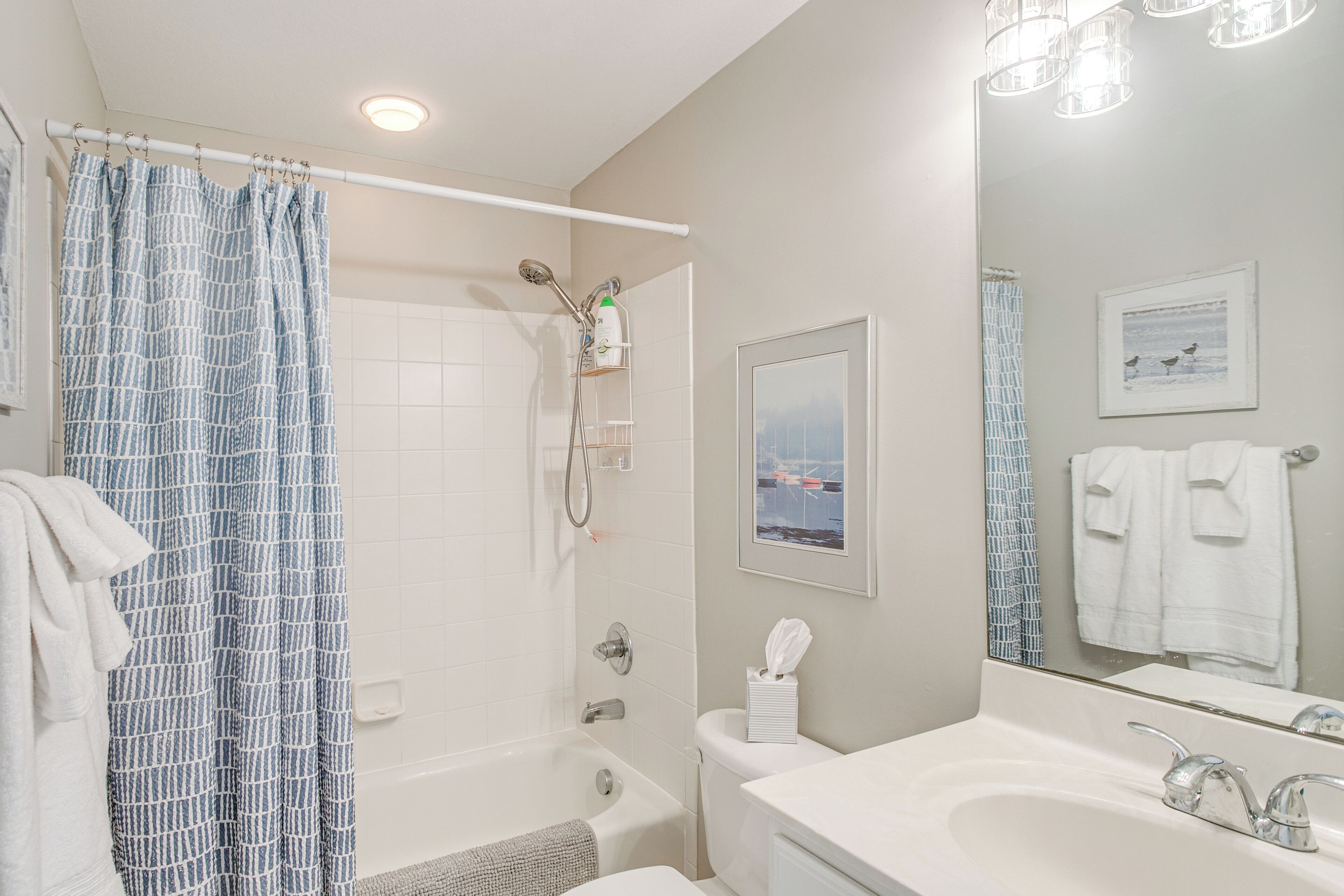 A bathroom with a bathtub, a shower, a sink, and a mirror.