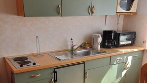 Una cuina compacta amb rentapelats, fogó i microones.