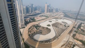 A high-rise building with a view of a cityscape and a large water feature. - Lux BnB Aykon City I Skyline Canal Views (Dubai)