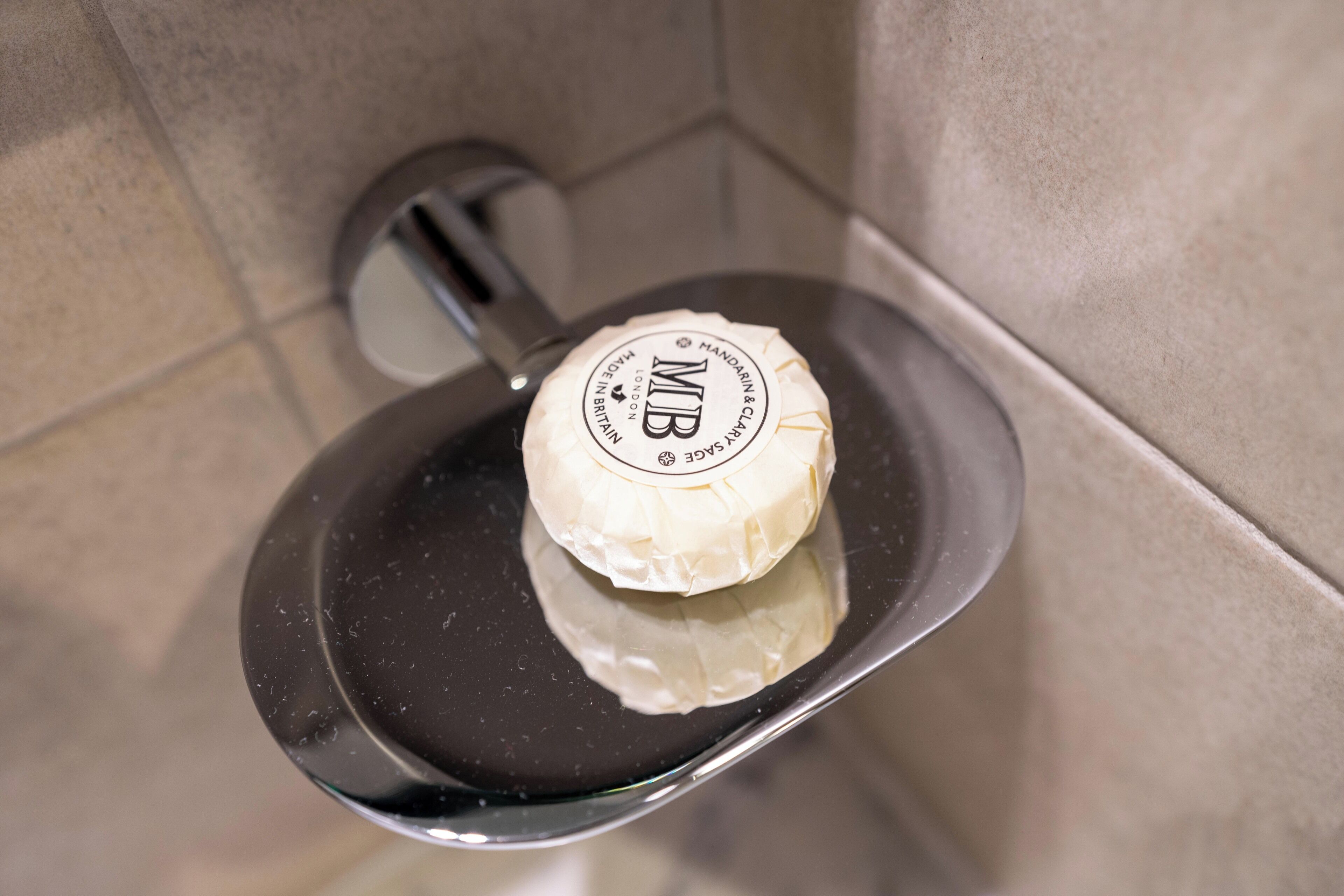 Un pain de savon posé sur un plateau noir, avec une étiquette.