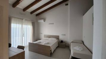 A hotel room with a large bed, a smaller bed, a desk, and a chair.