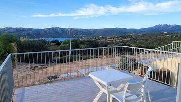 Habitación triple, vista parcial al mar | Terraza o patio
