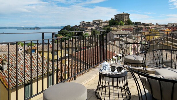 Un balcon avec vue sur une ville historique et un lac.