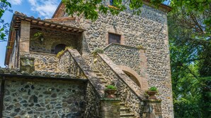 A stone building with a staircase leading to a wooden door. - La Capraccia (BOL334) by Interhome (Lago di Bolsena)