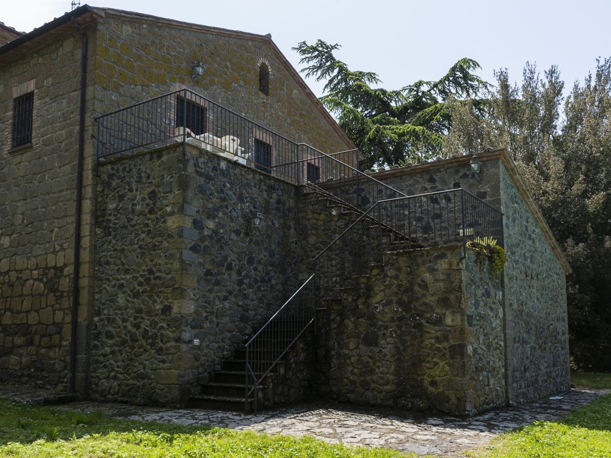 A stone building with a staircase leading to a balcony.