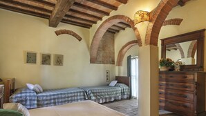 A bedroom with two beds, a dresser, and a mirror. - Terra Bianca (PAA136) by Interhome (Palaia)