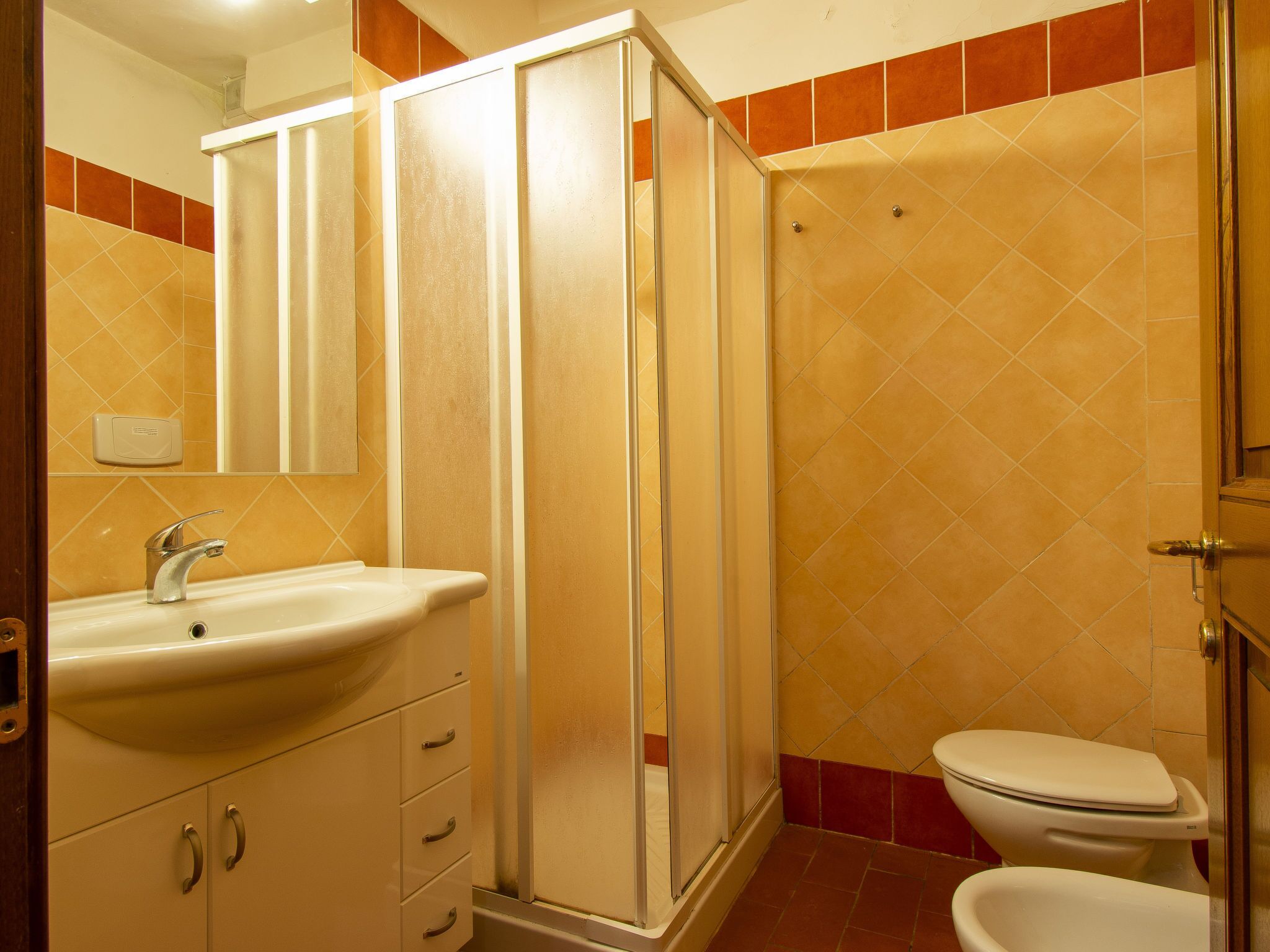 A bathroom with a shower, toilet, and sink.