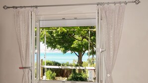 A window with a view of a tree and a body of water.
