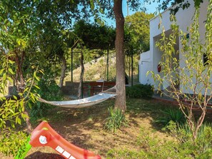 Relax in a peaceful outdoor setting surrounded by lush greenery and a serene atmosphere.