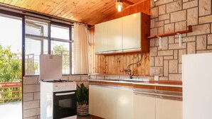 A kitchen with a stove, sink, and cabinets.