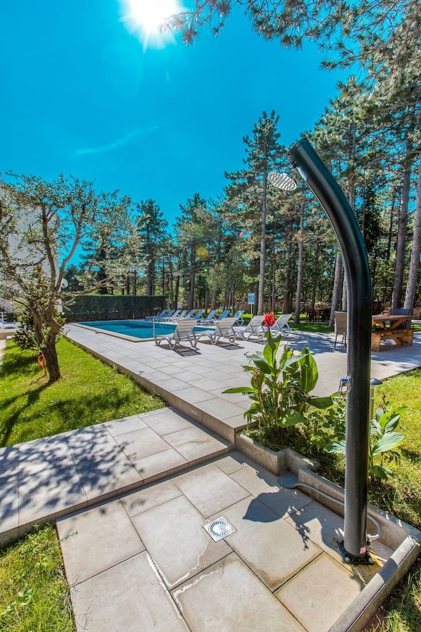 A poolside area with lounge chairs, a pool, and a picnic table.
